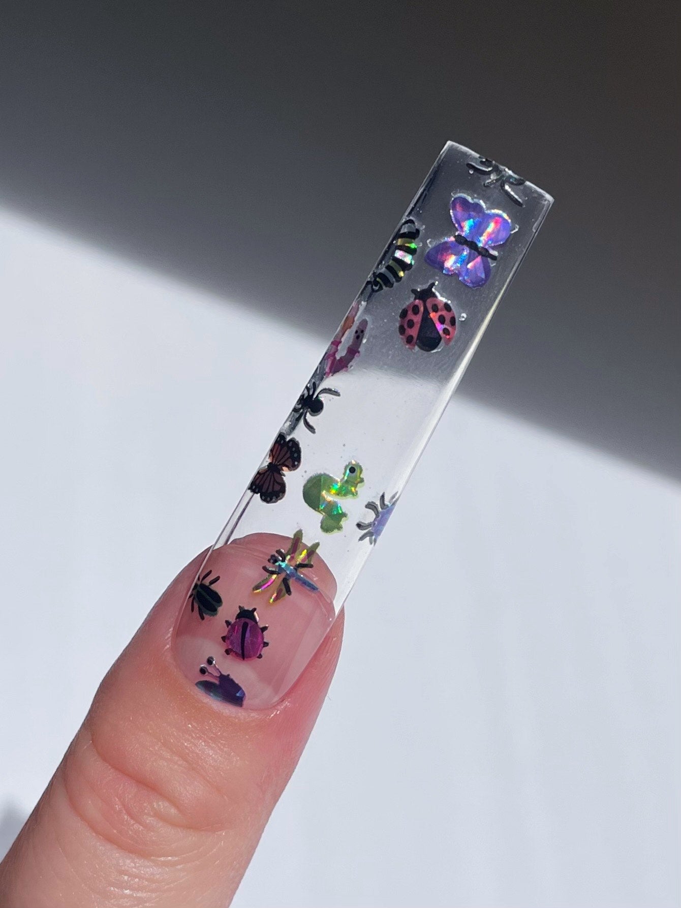 Long clear nail extension with holo bug stickers