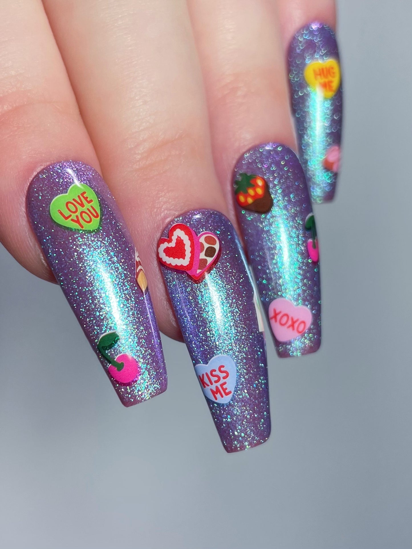 XOXO stickers on purple shimmery nails