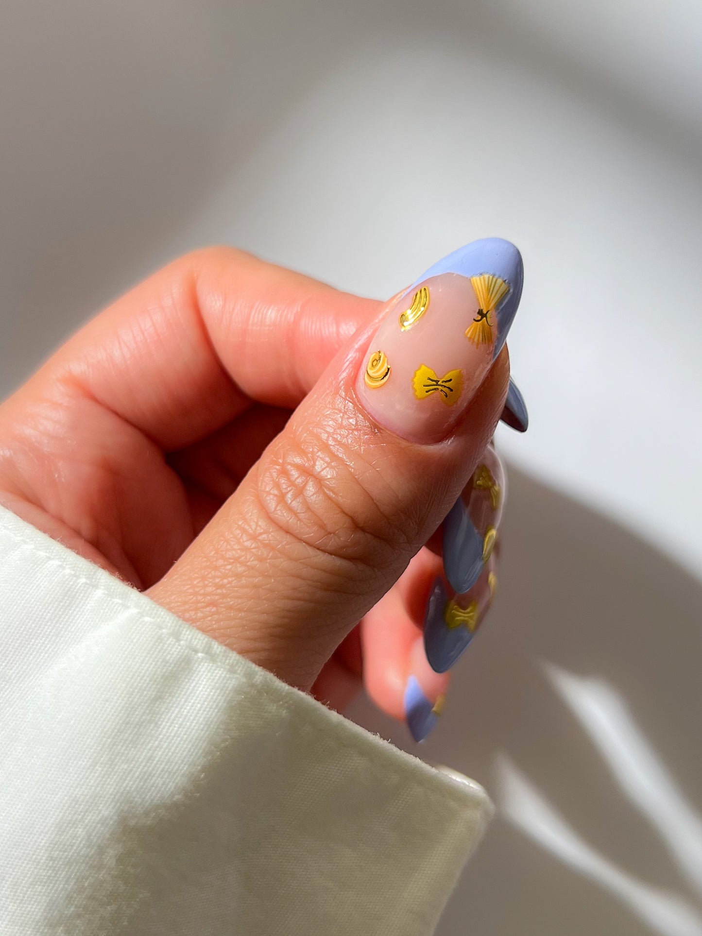Light blue french tip nail with yellow stickers