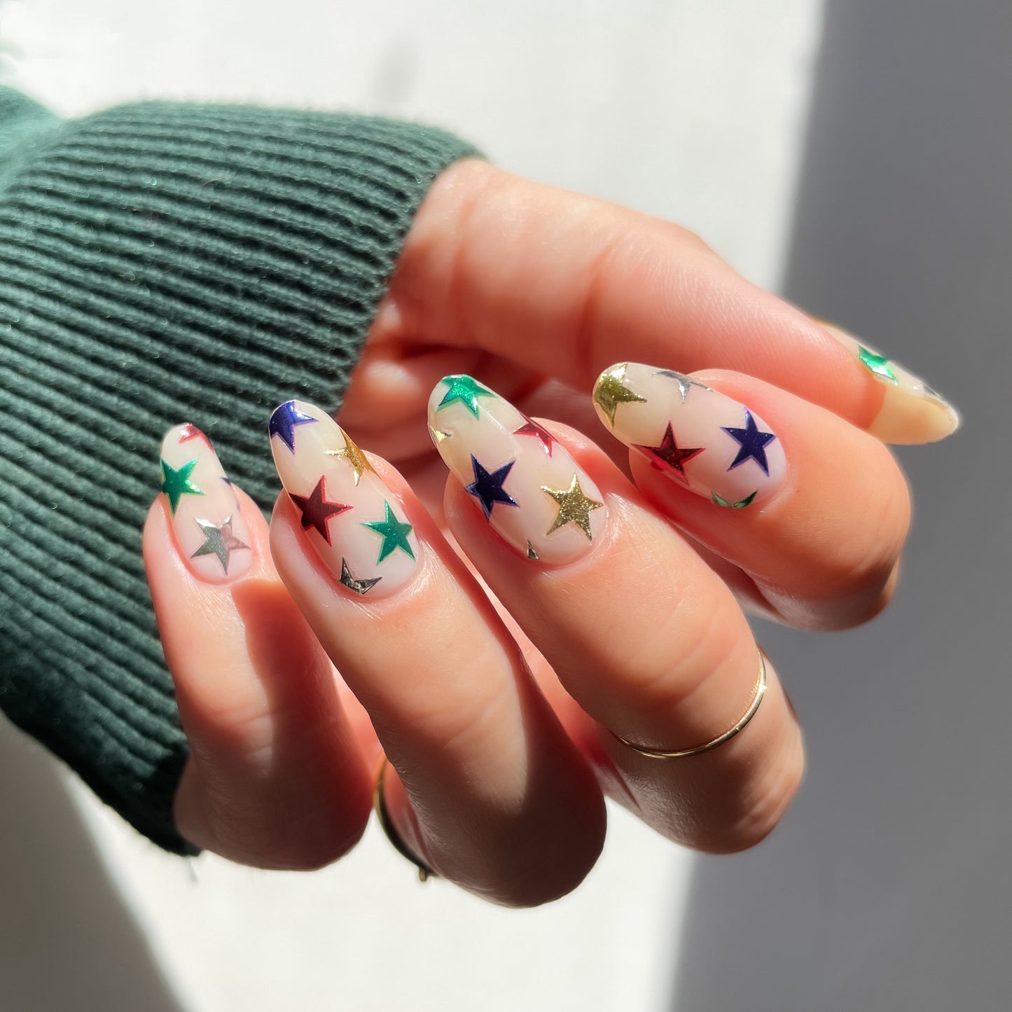 metallic star stickers on sheer white nail polish base