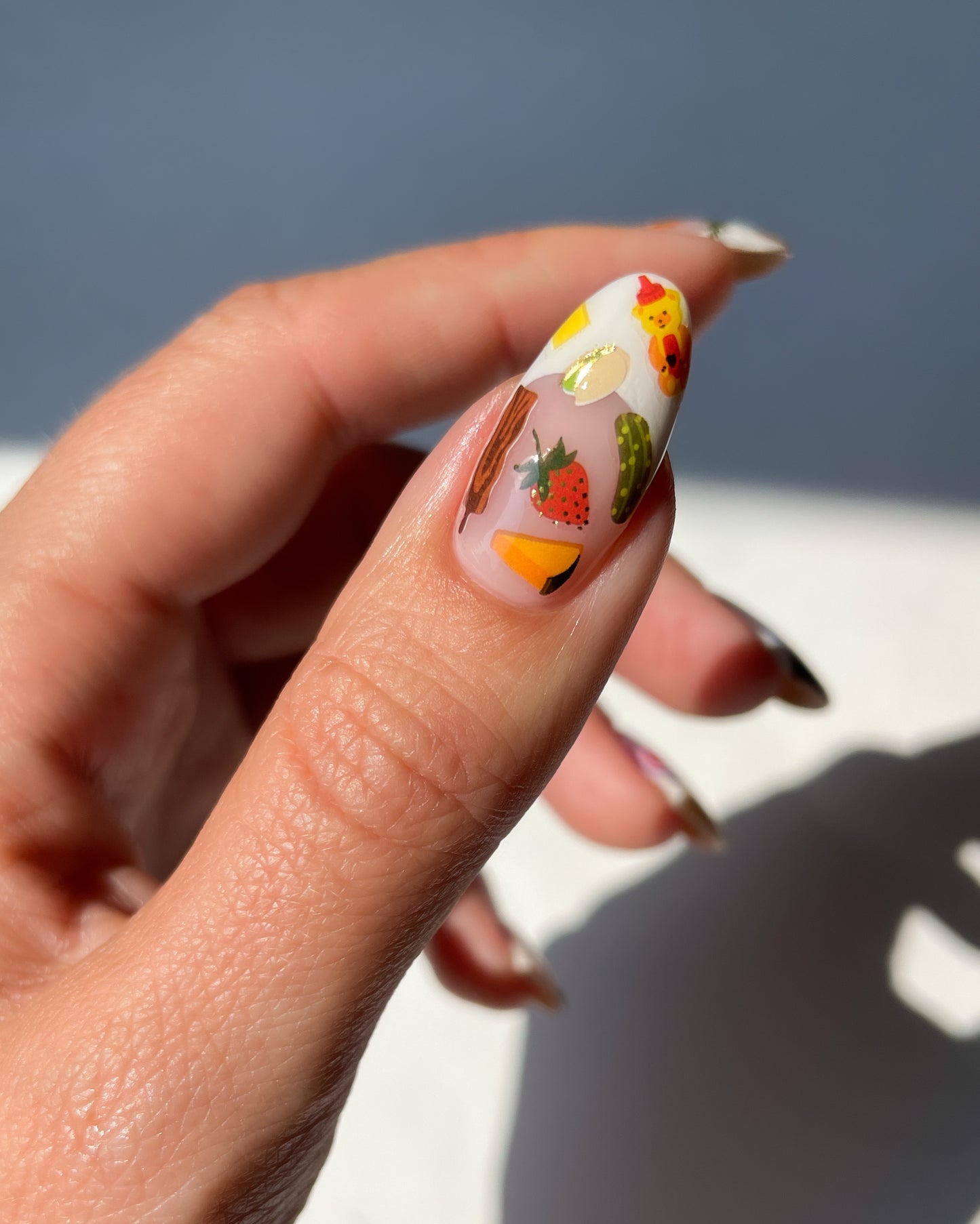 Thumb with French tip and nail art stickers on