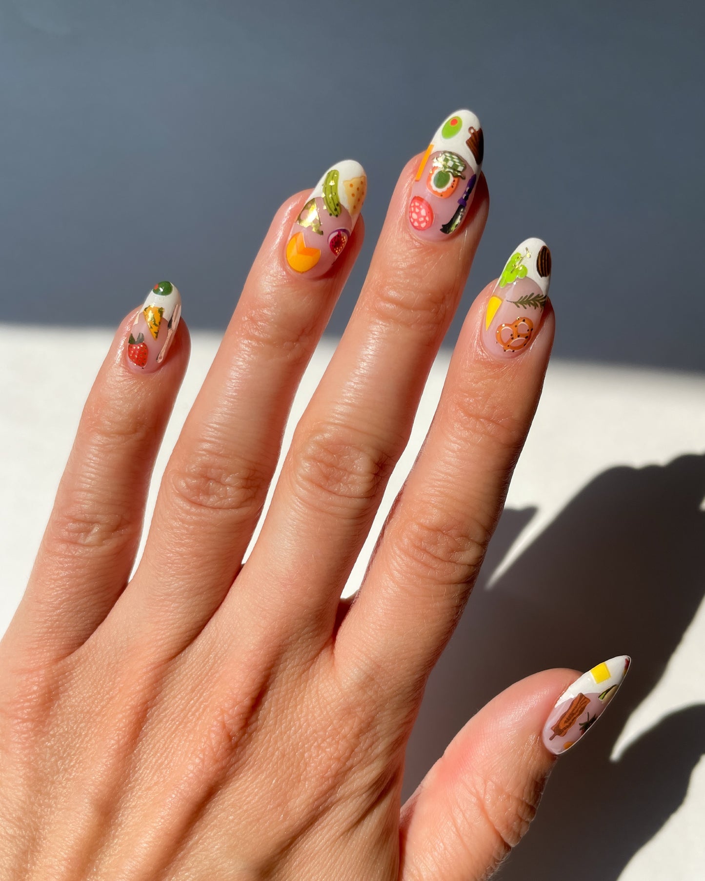 Hand with French tip nails and nail art stickers on