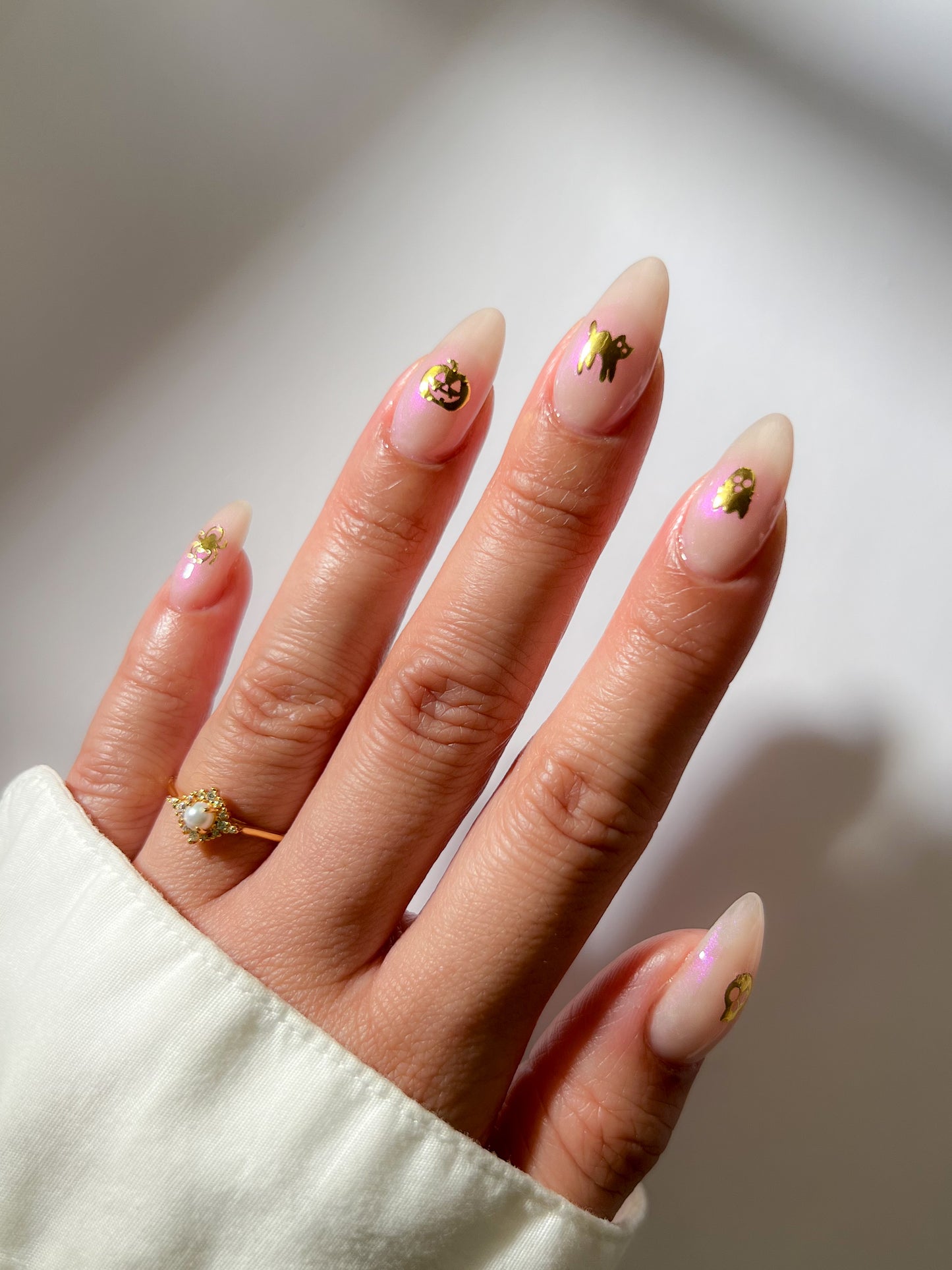 Sheer pink nails with a sticker in the middle
