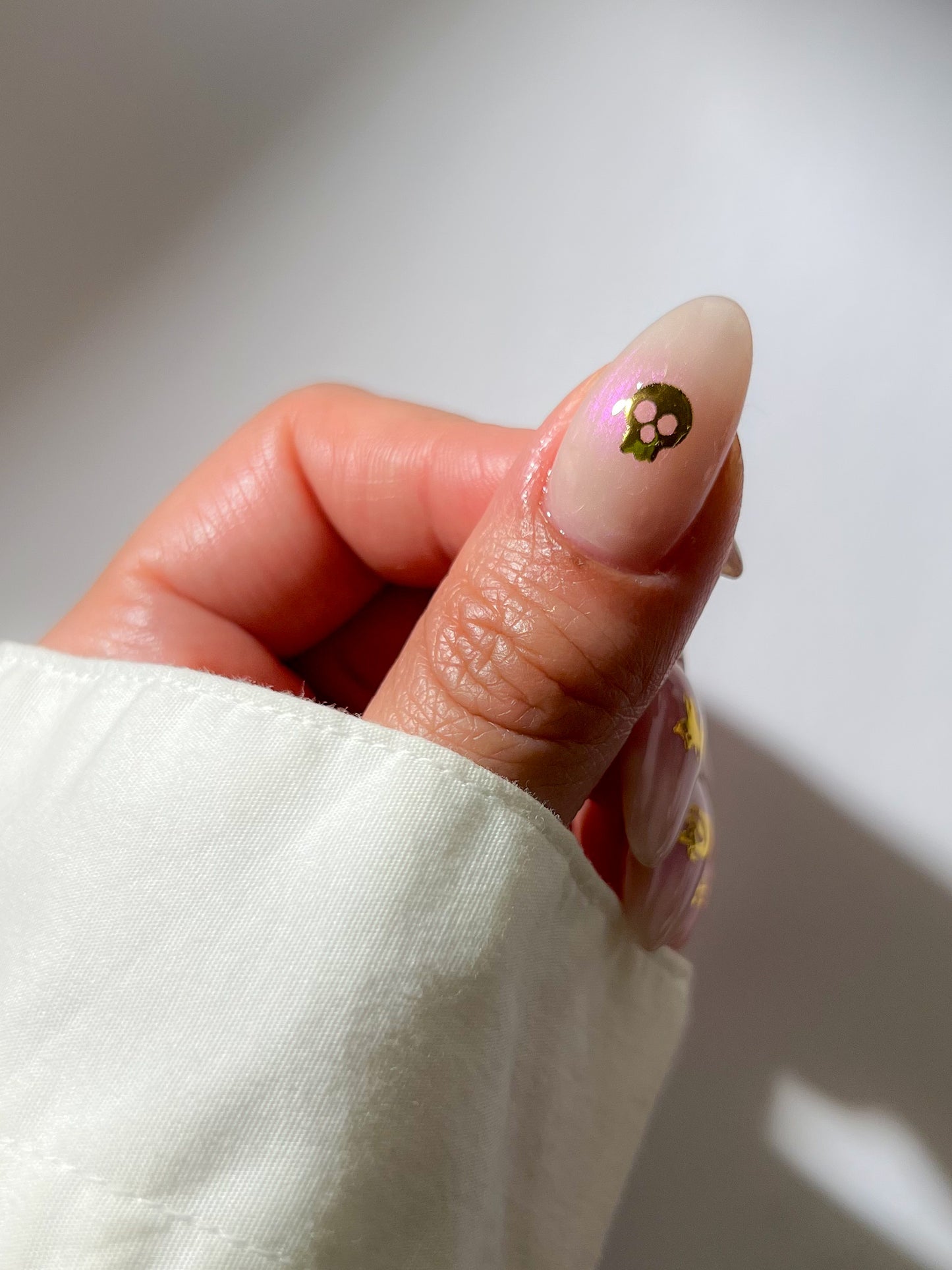 Sheer pink nail with a sticker in the middle