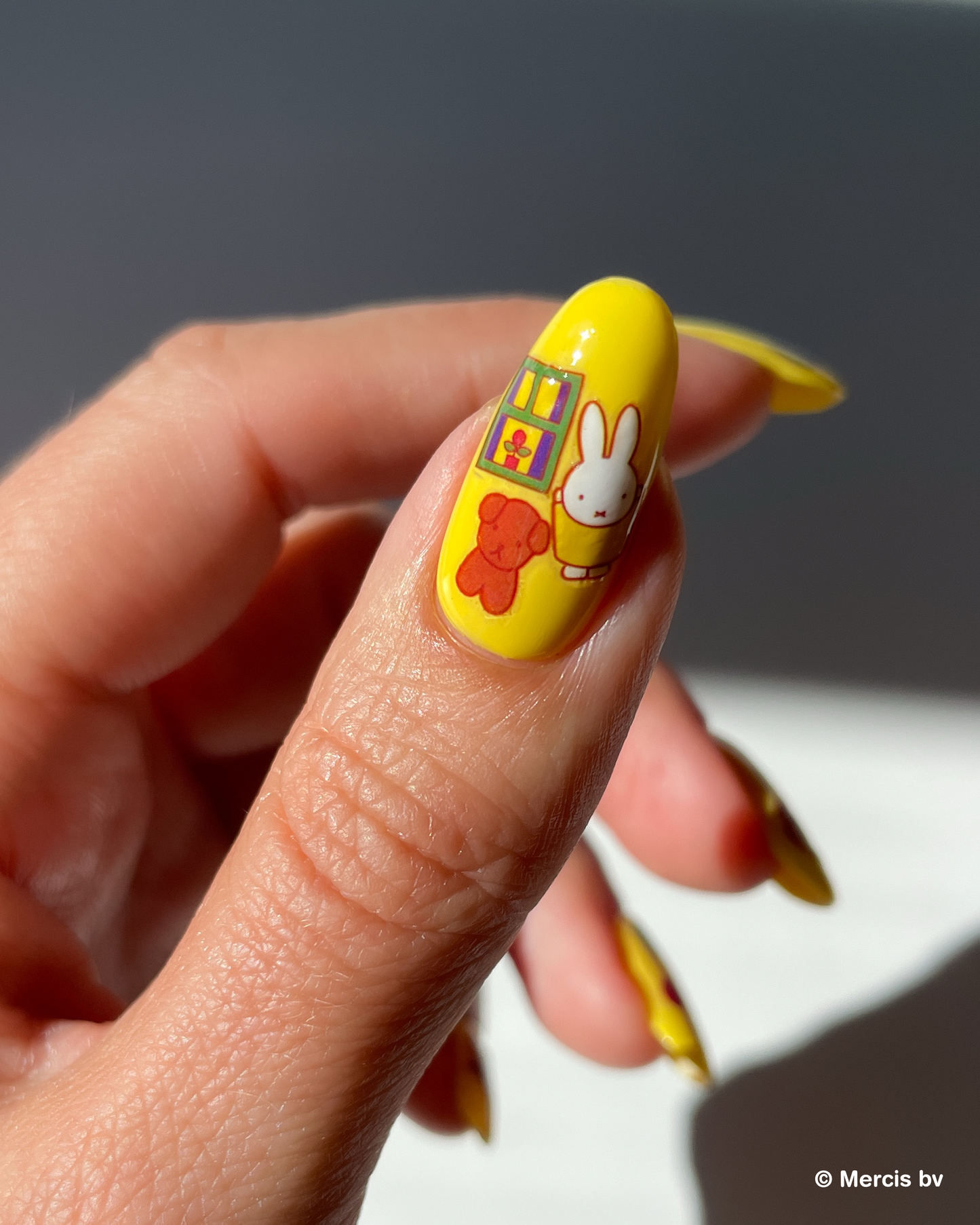 Nail with yellow nail polish and miffy nail art stickers