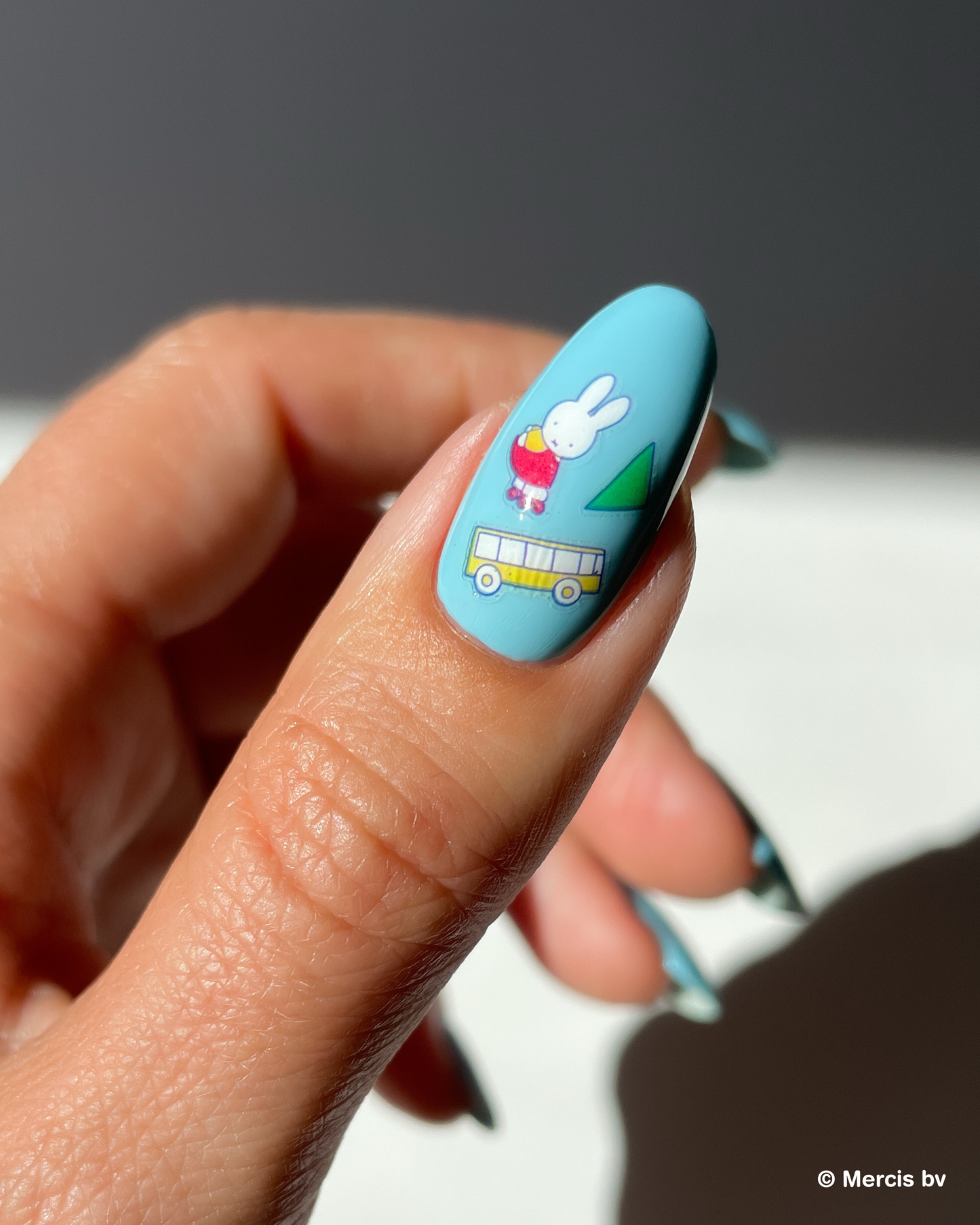 Nail with blue nail polish and miffy nail art stickers