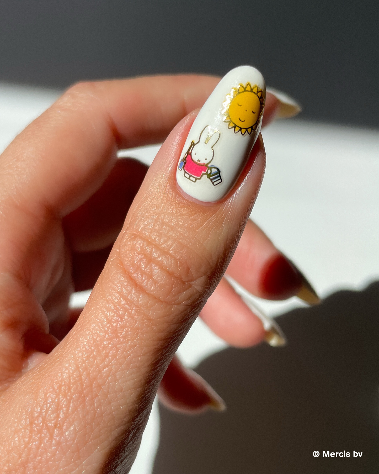 Nail with white nail polish and miffy nail art stickers