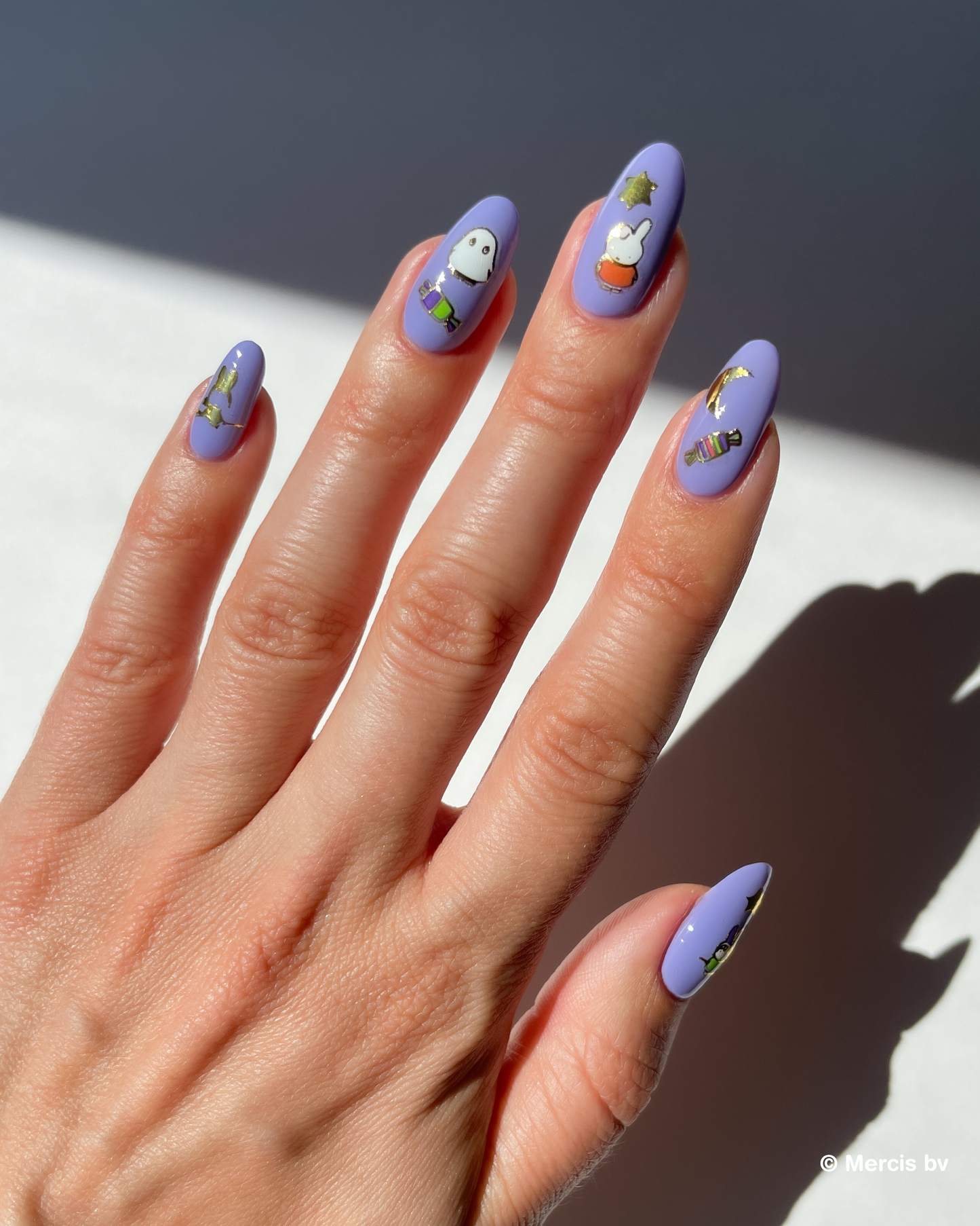 Hand with purple nail polish and miffy nail art stickers on a neutral background