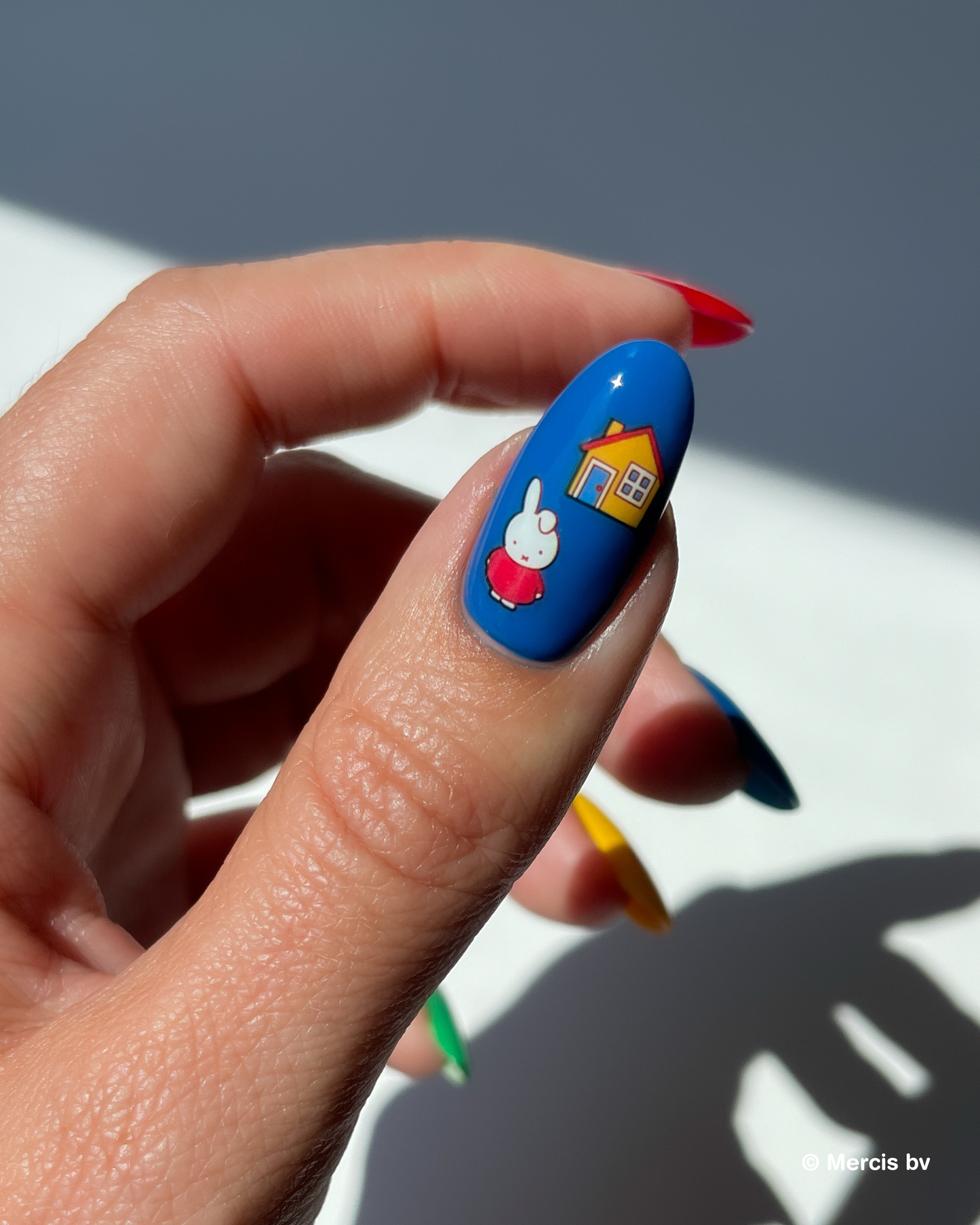 Nail with deep blue nail polish and miffy nail art stickers