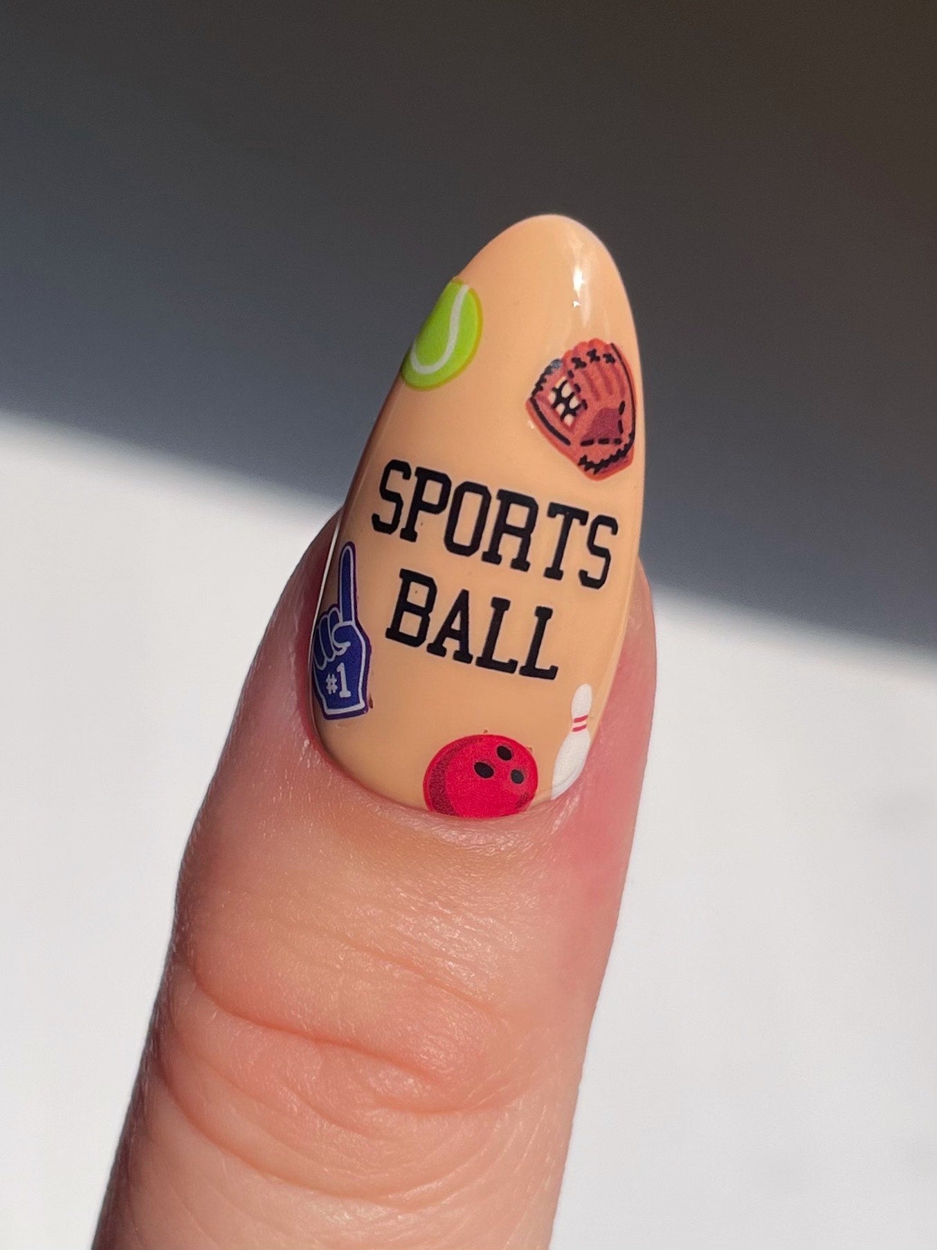 Stickerbook nails with Sports Ball stickers on beige nails