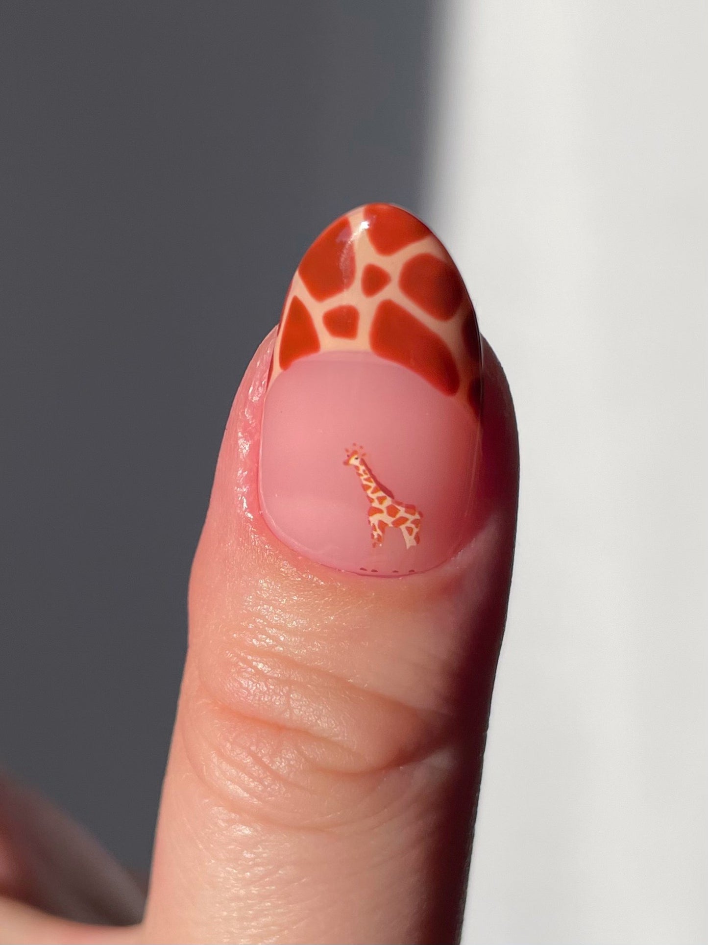 Giraffe print french tip nail with a giraffe sticker