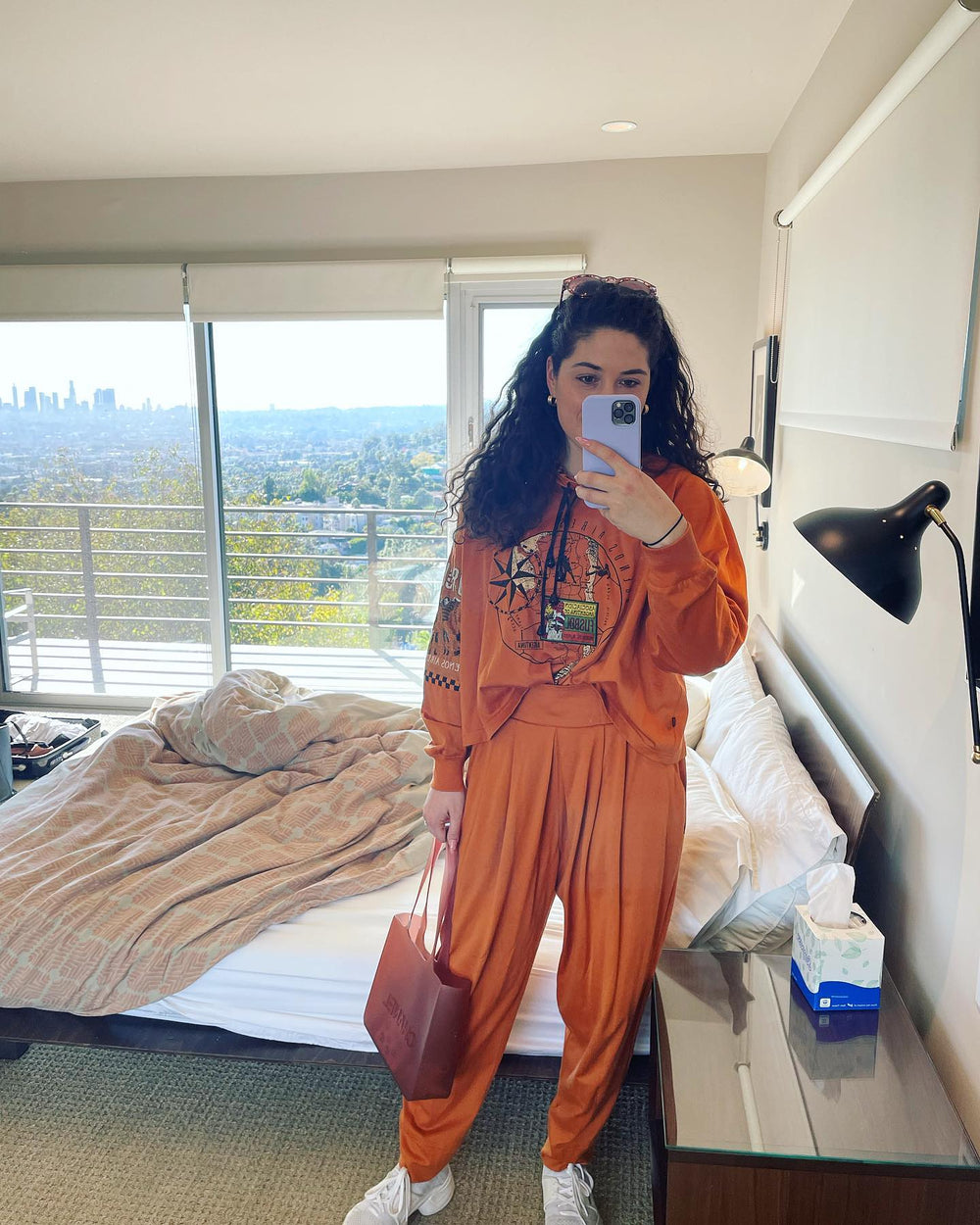 Jules in an orange outfit taking a selfie