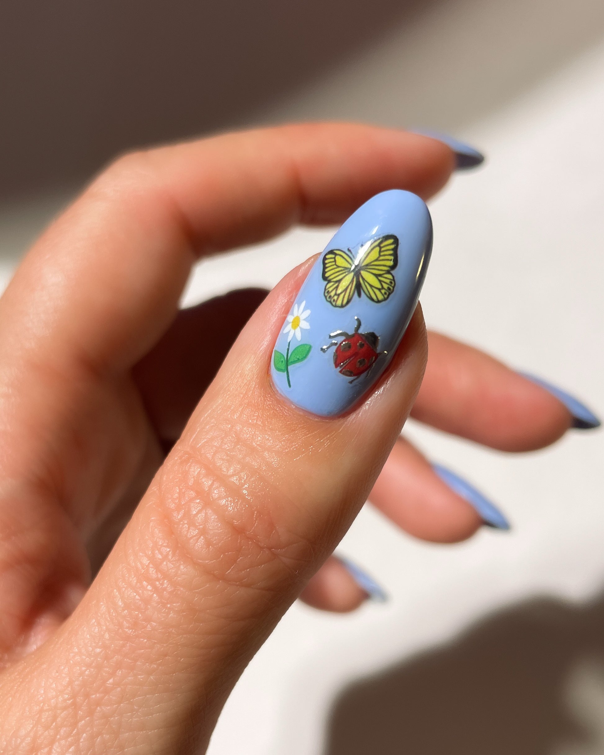 Berry Patch stickers on light blue nails
