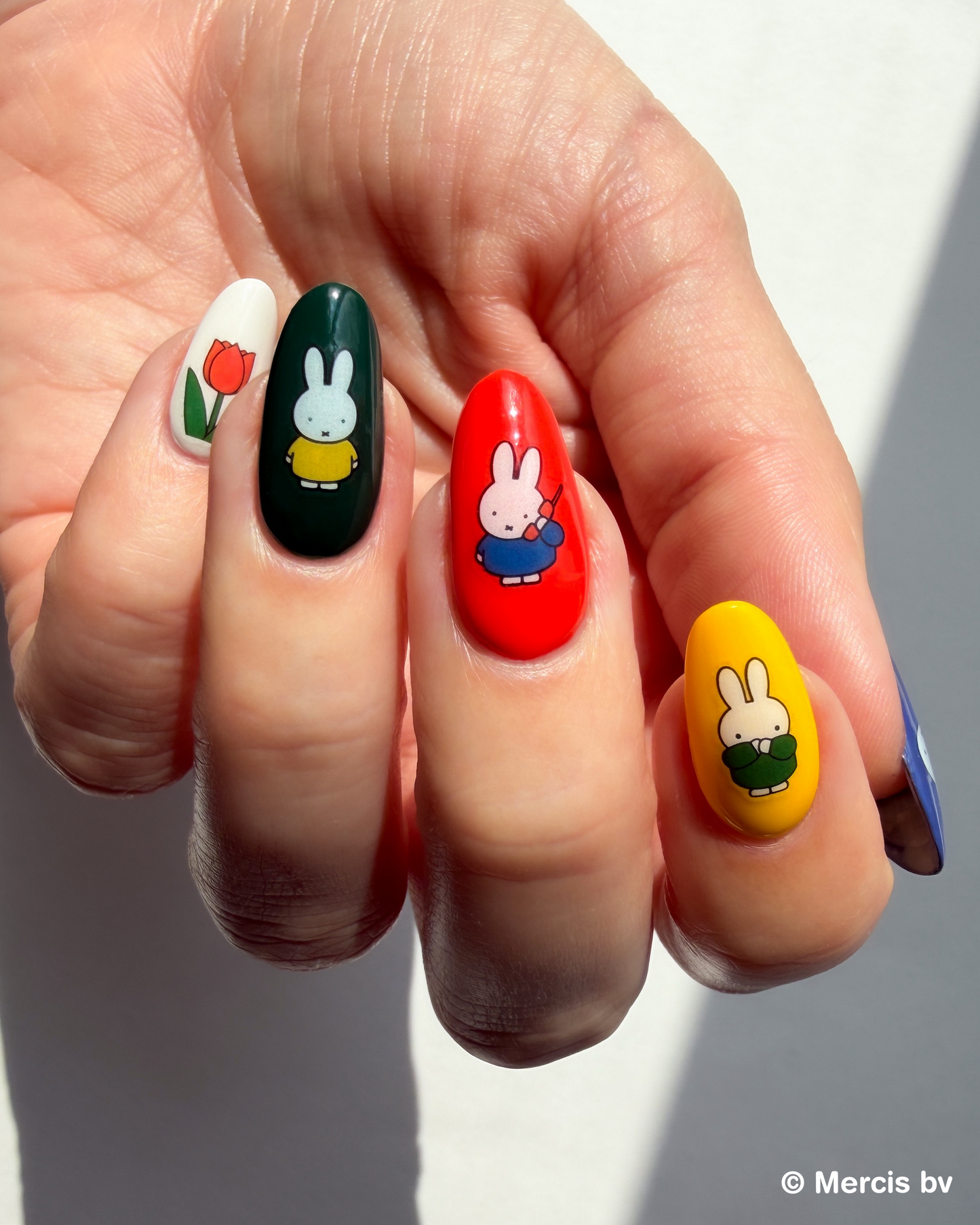 Nails with Miffy stickers on a neutral background