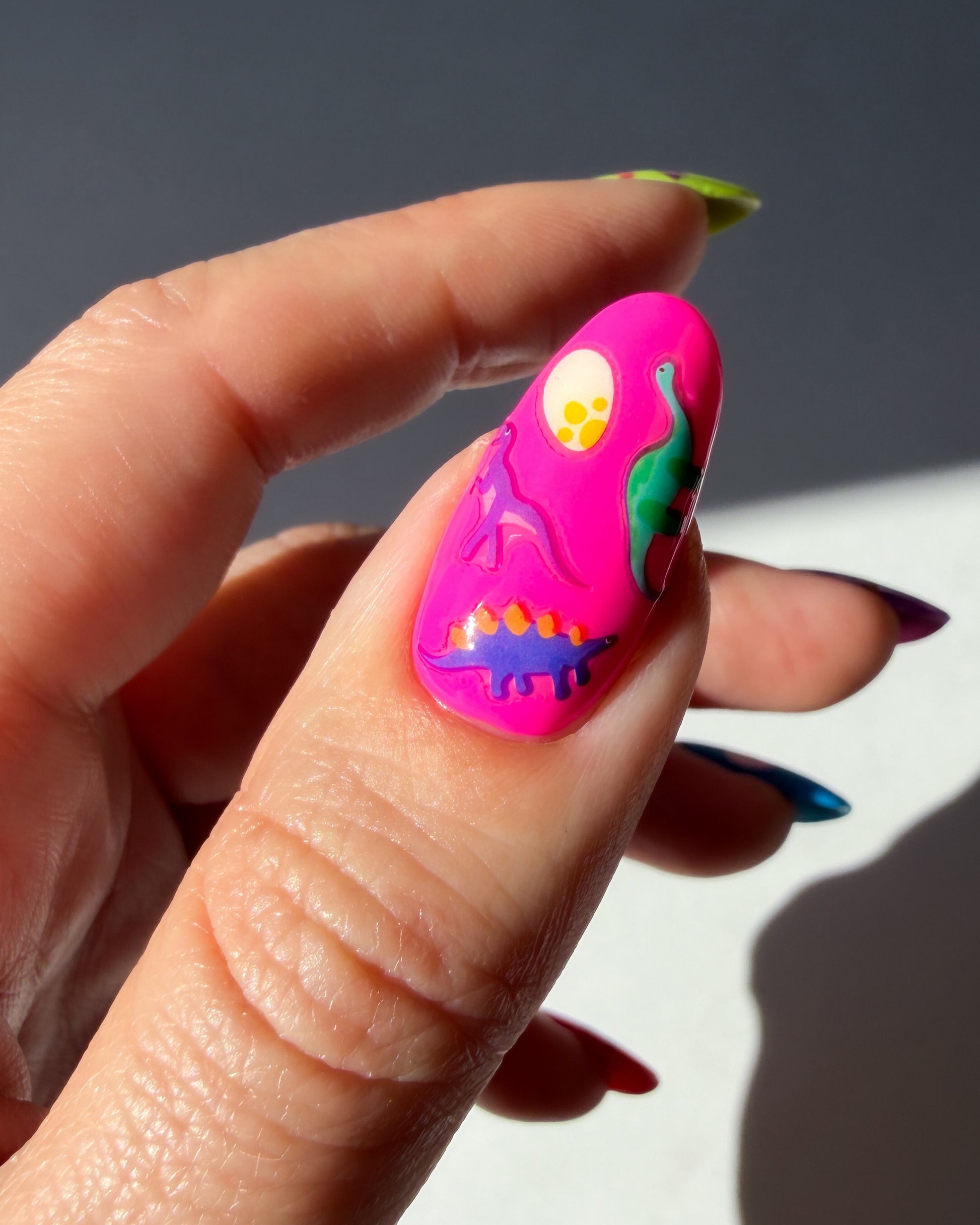 Dinos on a neon pink nail