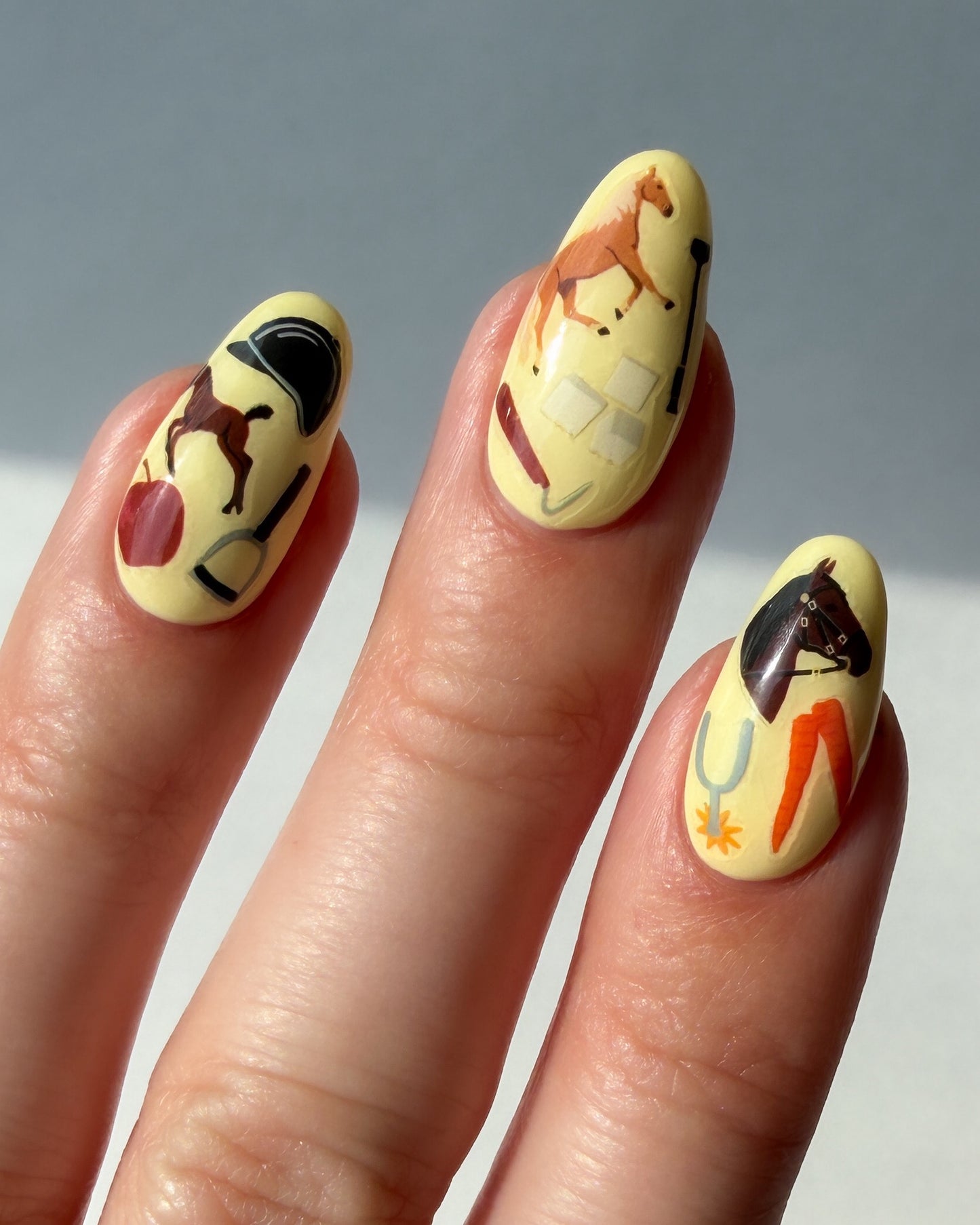 Nails with yellow nail polish and Horse Girl nail art stickers