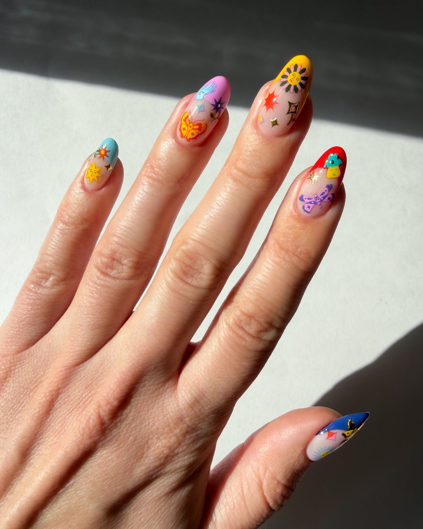 Jardin Estelar Stickers on multicolored french tip nails