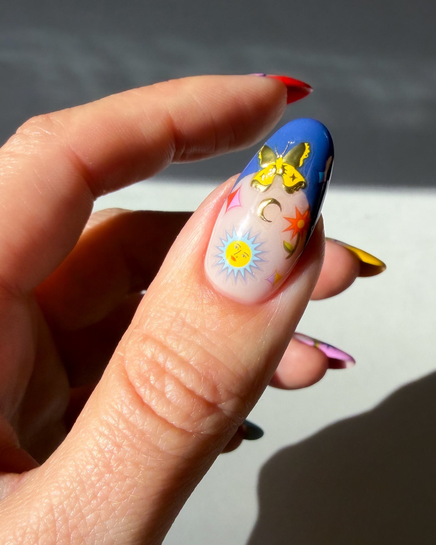 Jardin Estelar Stickers on a blue thumb french tip nail