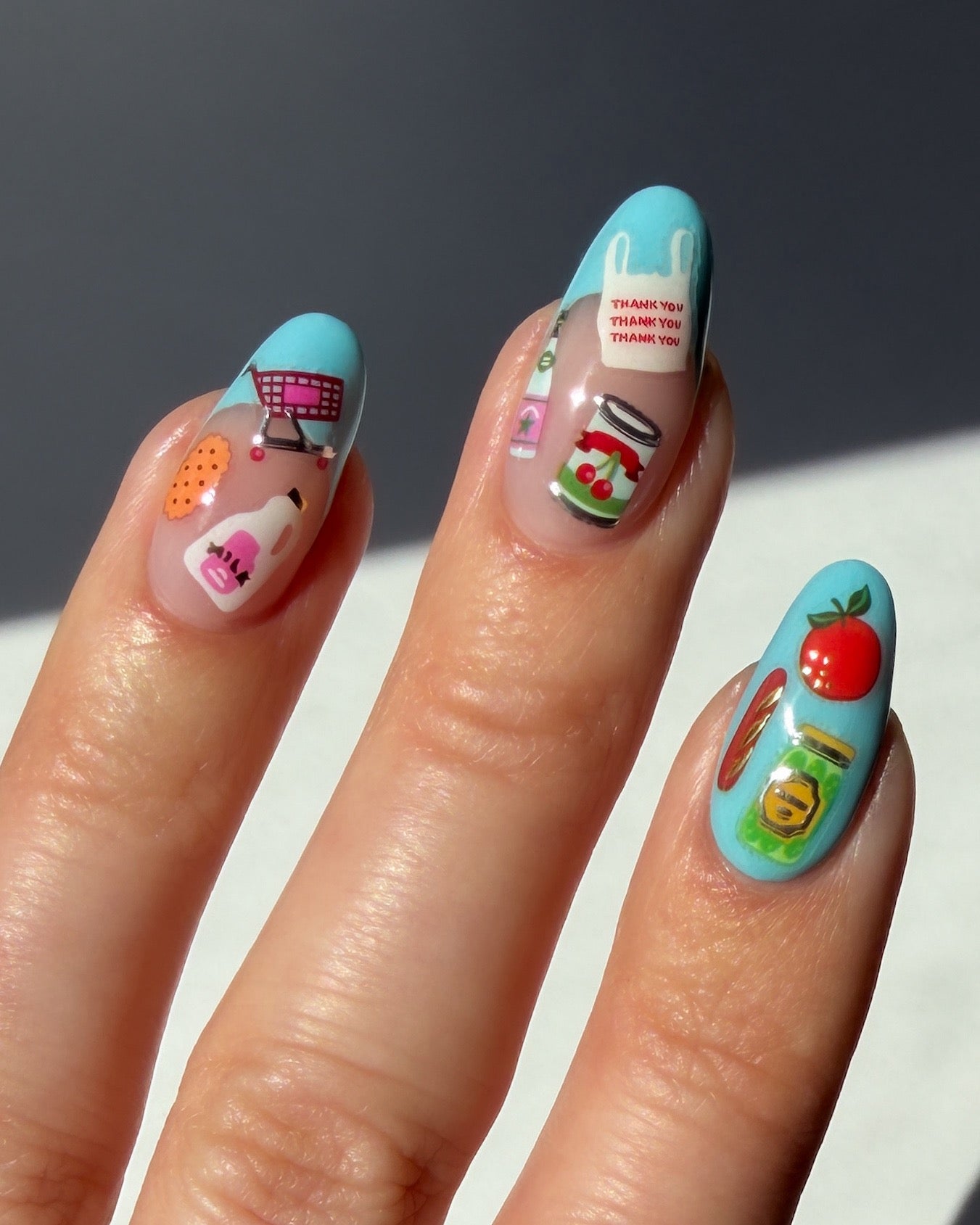 Nails with colorful nail art stickers on a neutral background