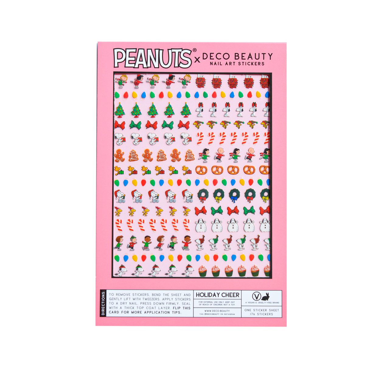 A flat lay of Peanuts x Deco Beauty Holiday Cheer nail art stickers, with festive stickers including Christmas trees, candy canes, snowmen, and Peanuts characters in light pink packaging.