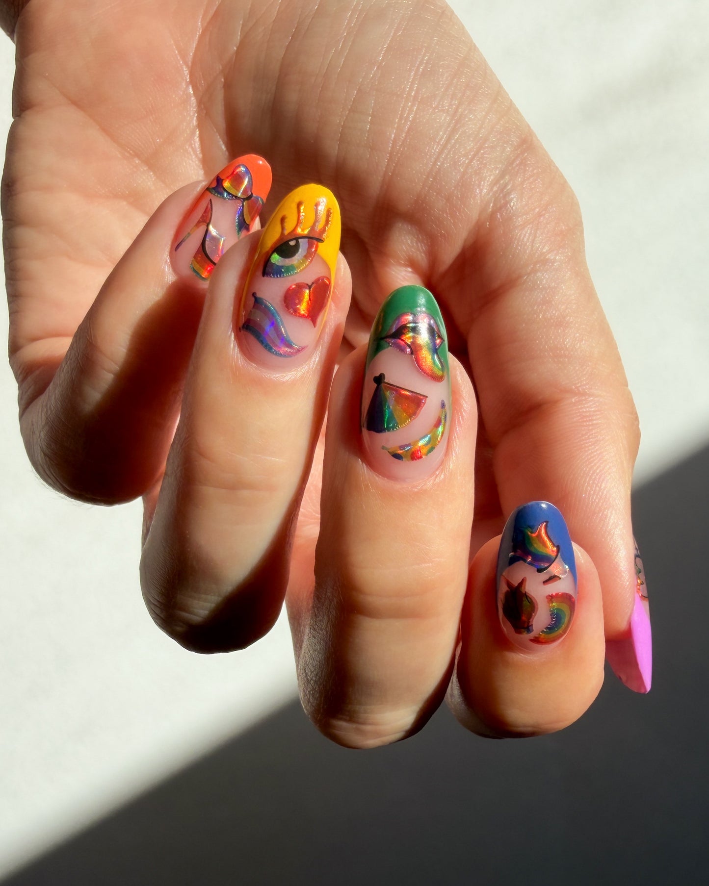 Hand with colorful nail art on a neutral background