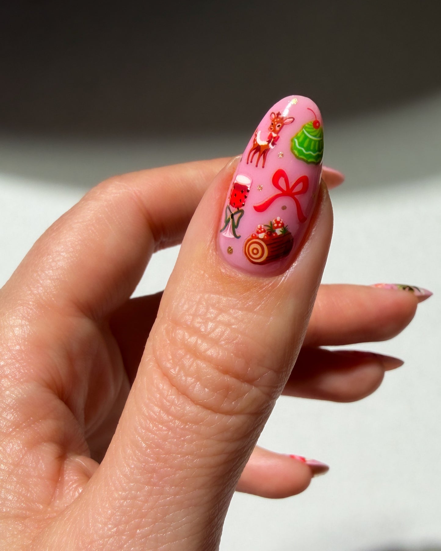 Santa Baby stickers on a pink nail