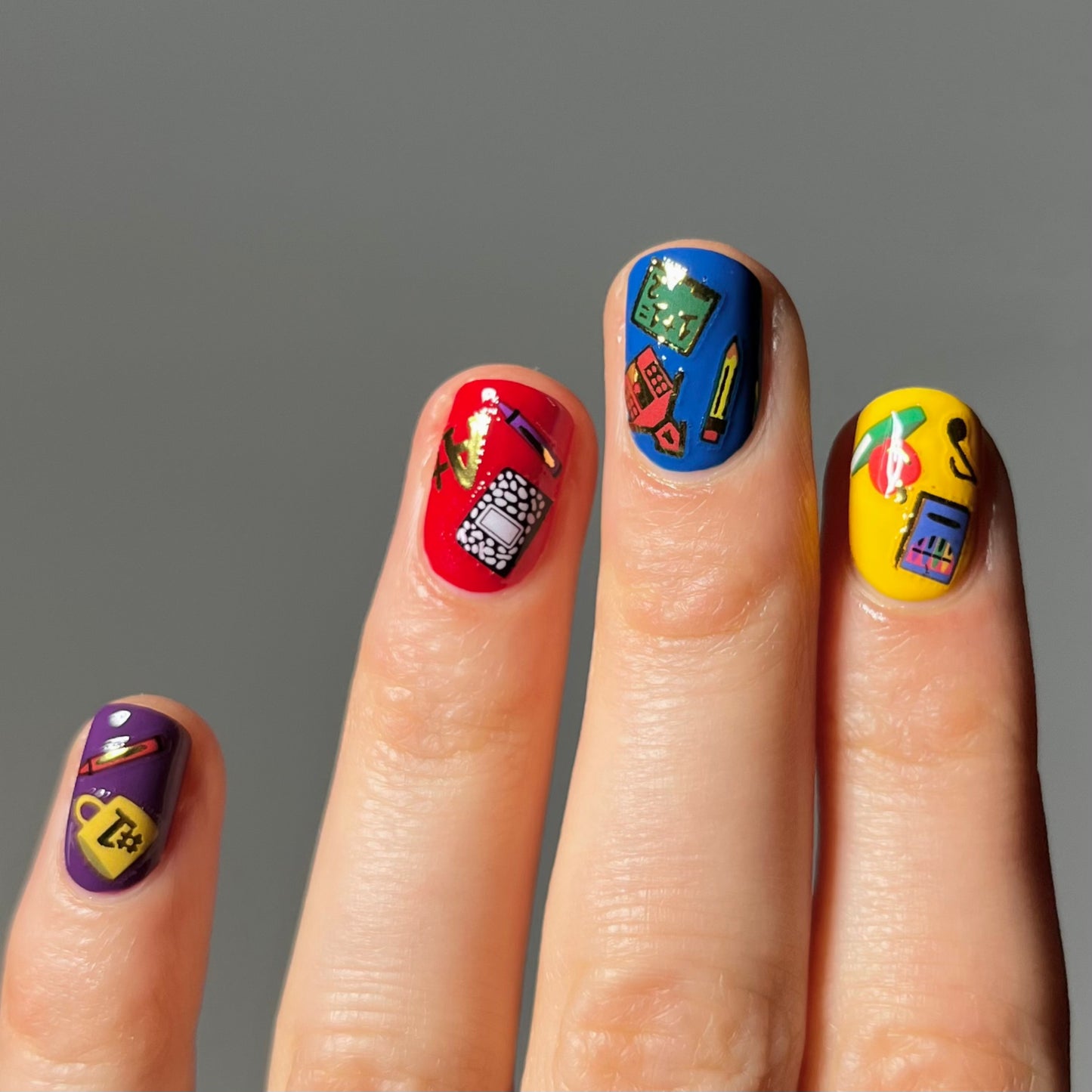 Yellow, blue, red, and purple nails with stickers