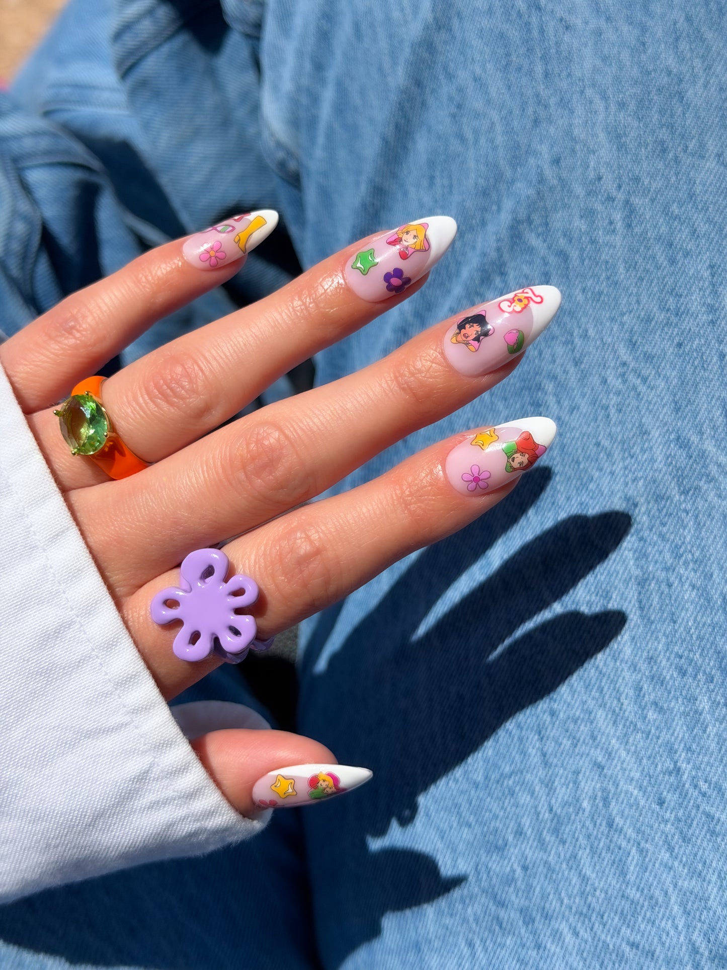 Nail with colorful stickers on a blue denim background