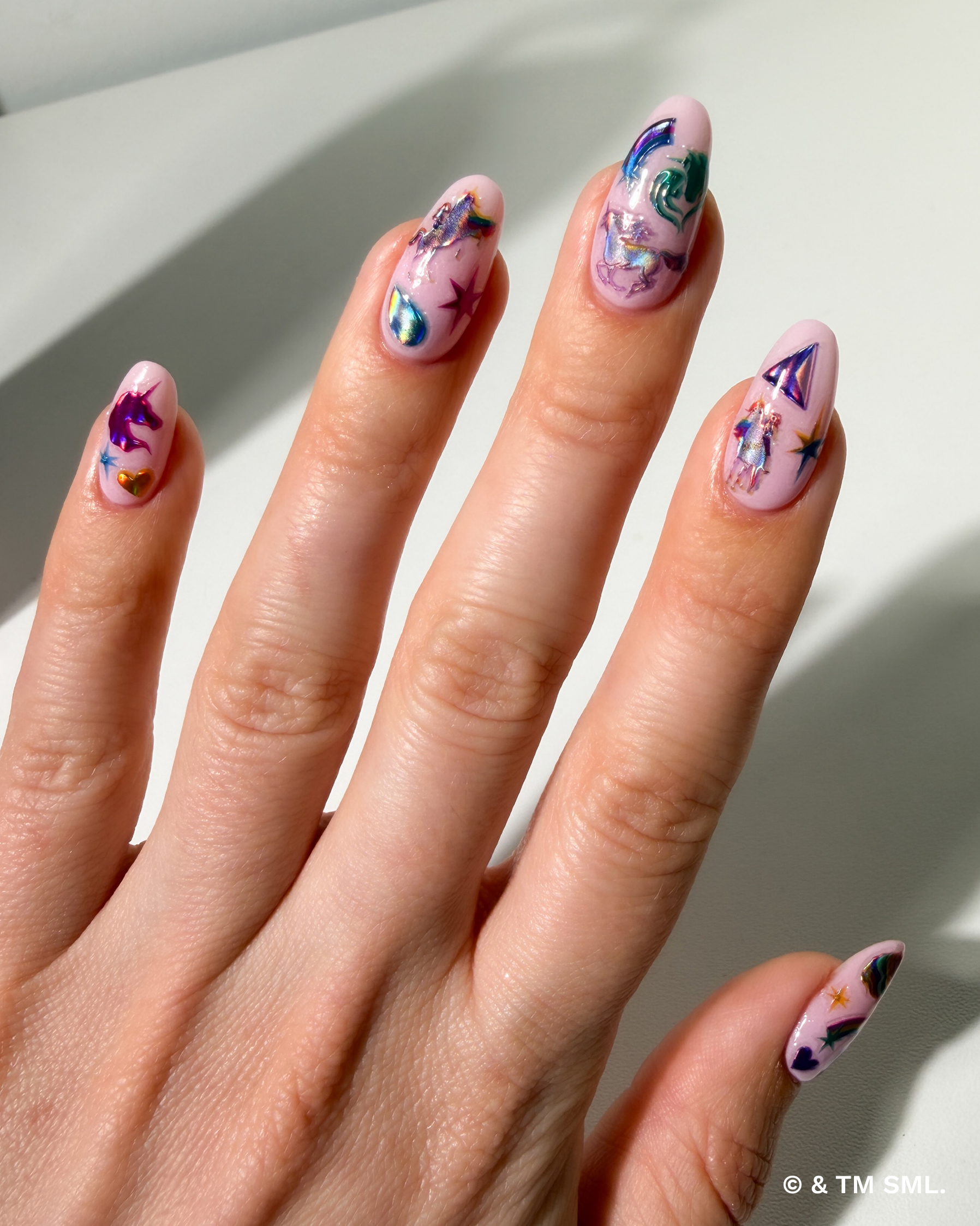 Hand with colorful nail art on a light background