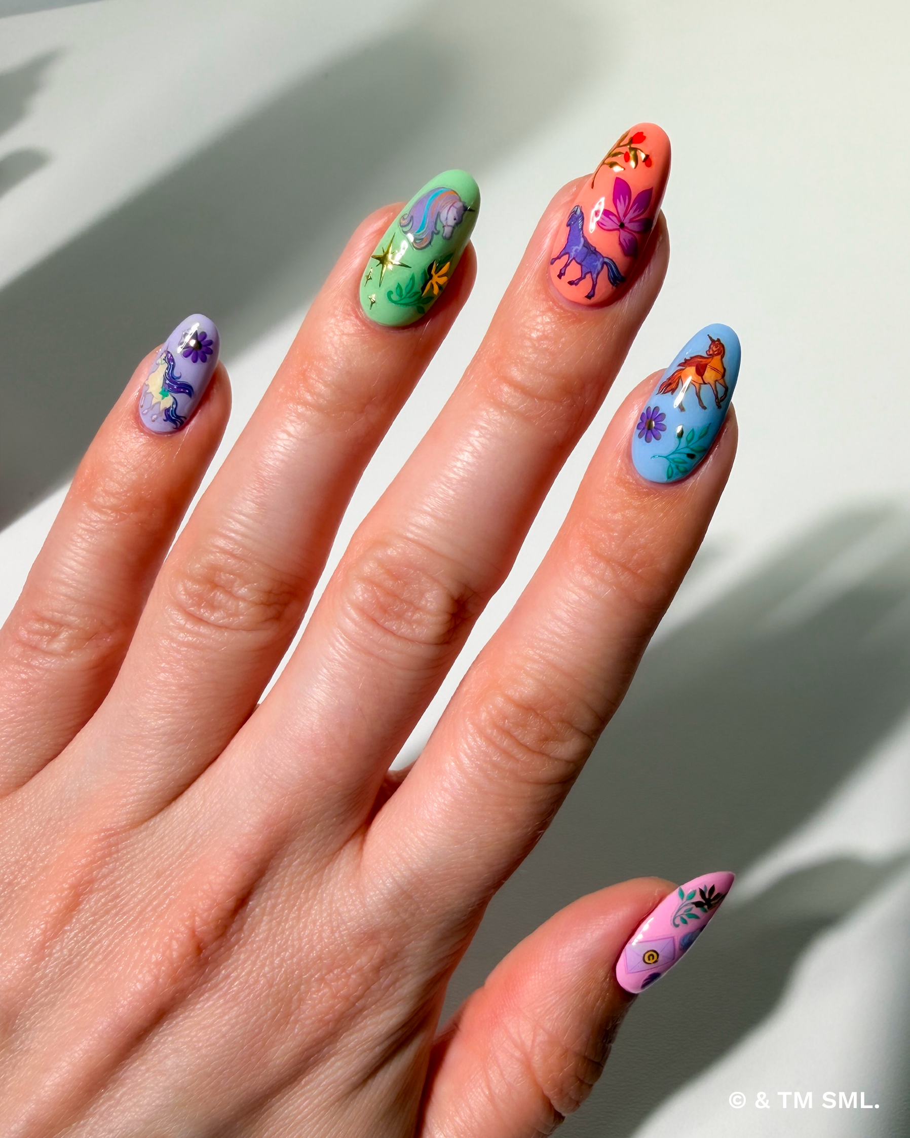 Hand with colorful nail art on a light background
