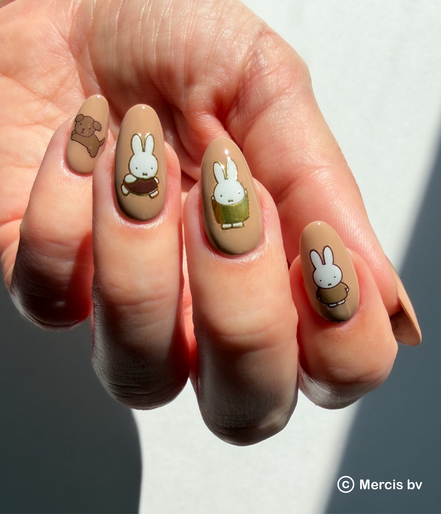 Nails with cartoon character designs on a neutral background
