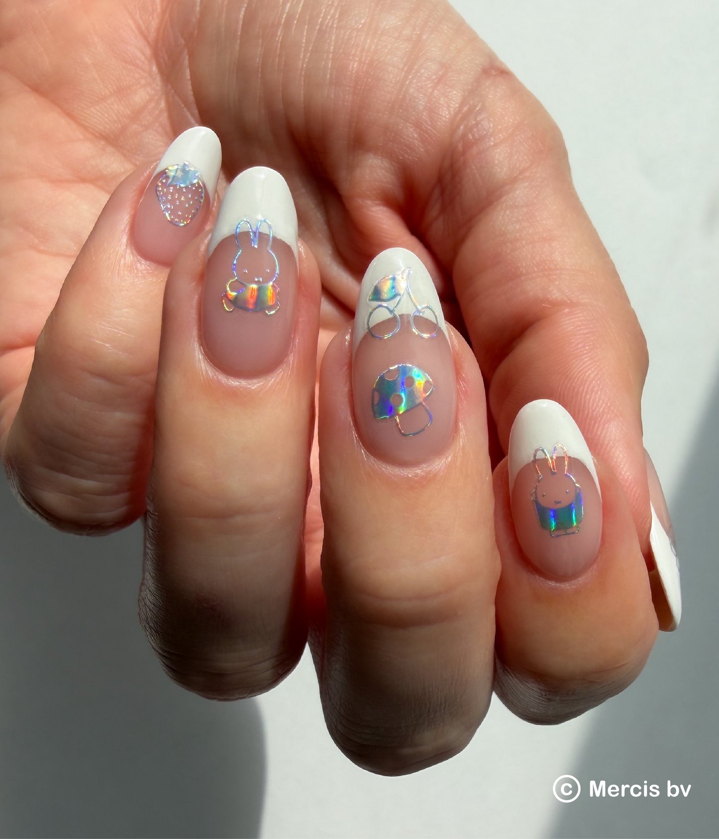 Nails with holo nail art stickers on a neutral background