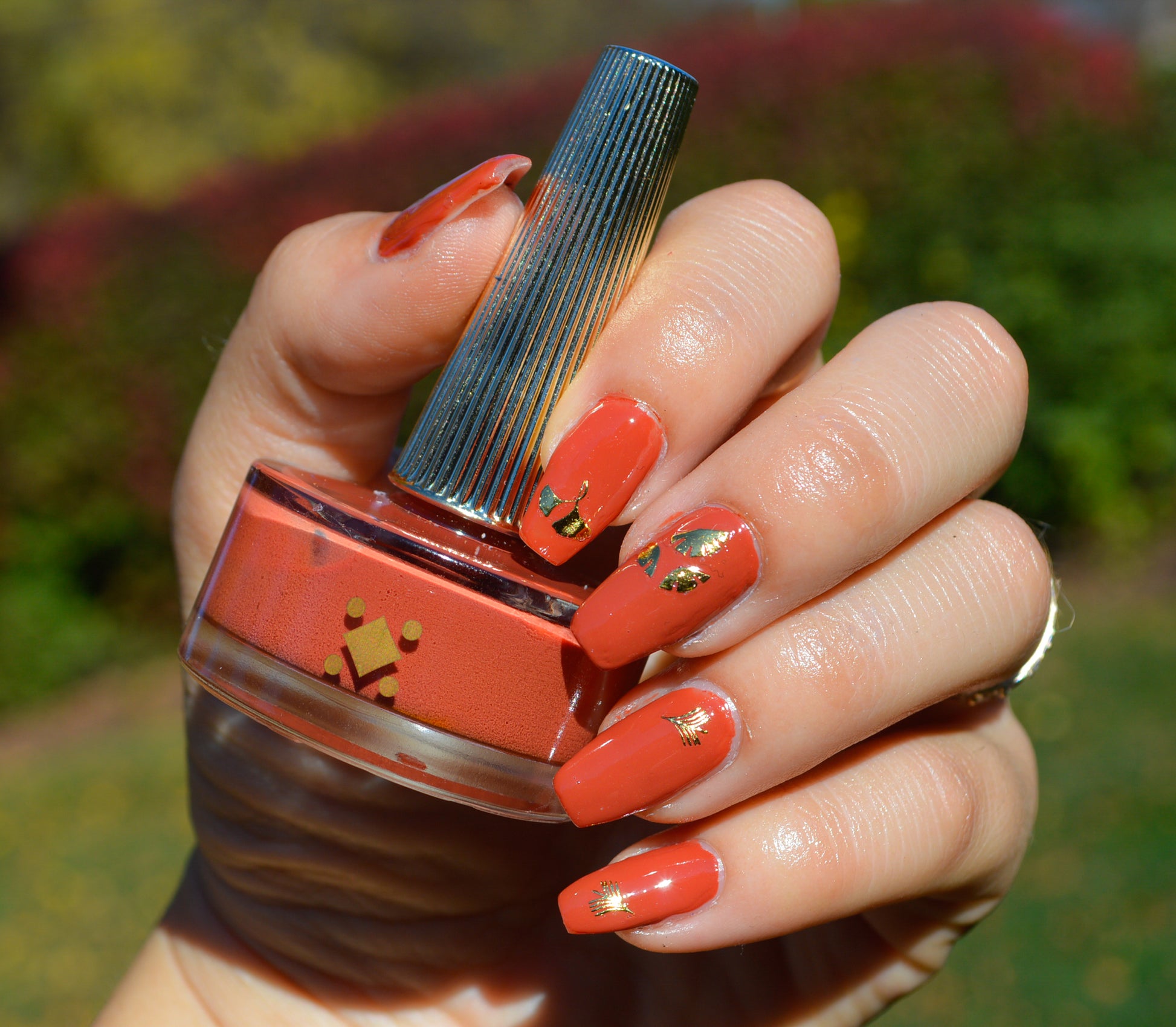 orange nails with gold leaf stickers