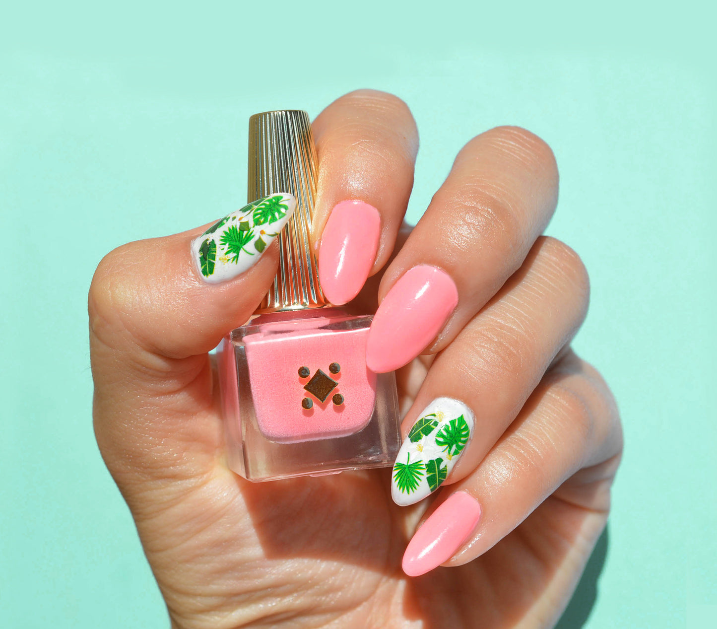 pink nails with green leaves on ring finger and thumb